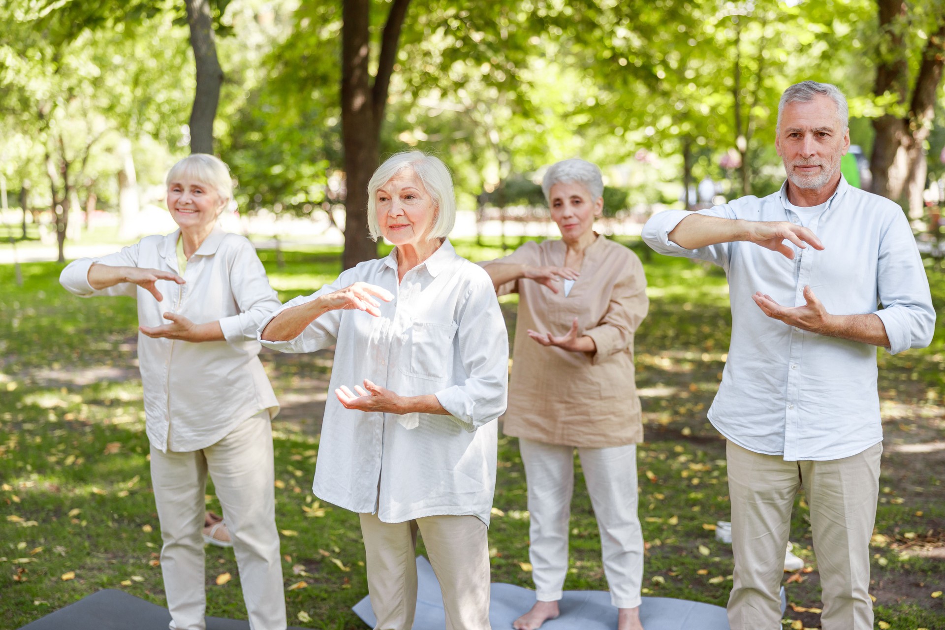 Smiling elderly people practicing qigong in the park