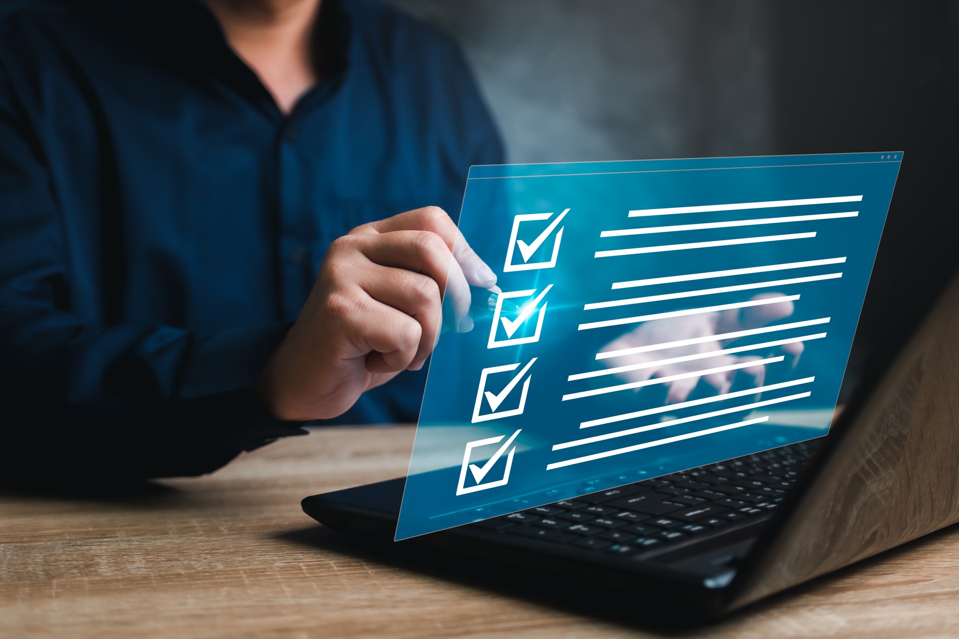 Business concept and smart checklist on virtual screen,A man use a pen marking about exploring the topics on the digital form check sheet and use a laptop working in a modern office