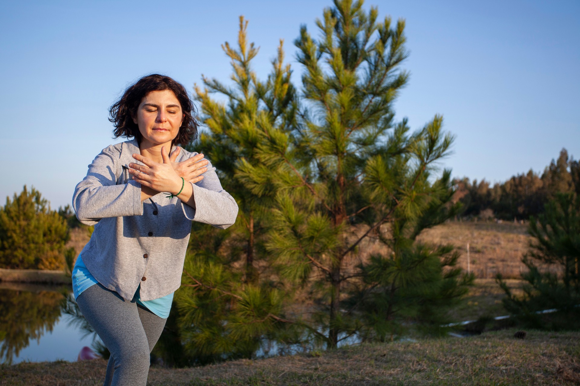 Mature woman practicing chi kung ( or tai chi chuan ) outdoors. Digital Detox concept.